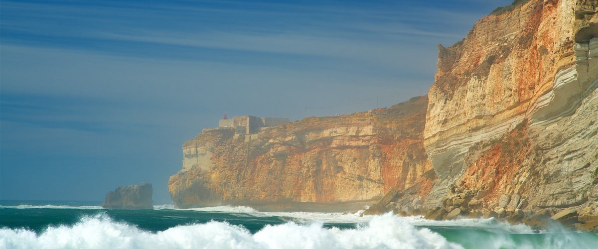Nazare Beach which includes rugged coastline, general coastal views and surf