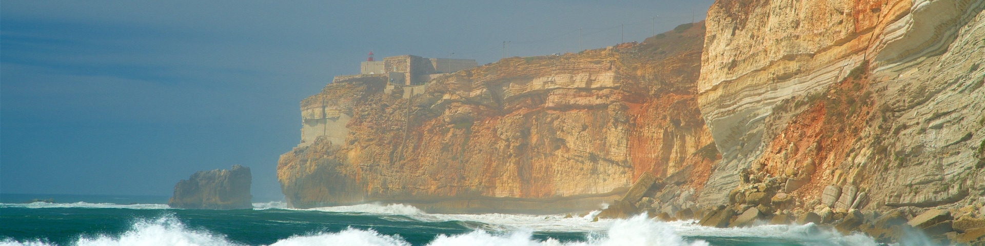 Nazare Beach showing waves, rocky coastline and general coastal views