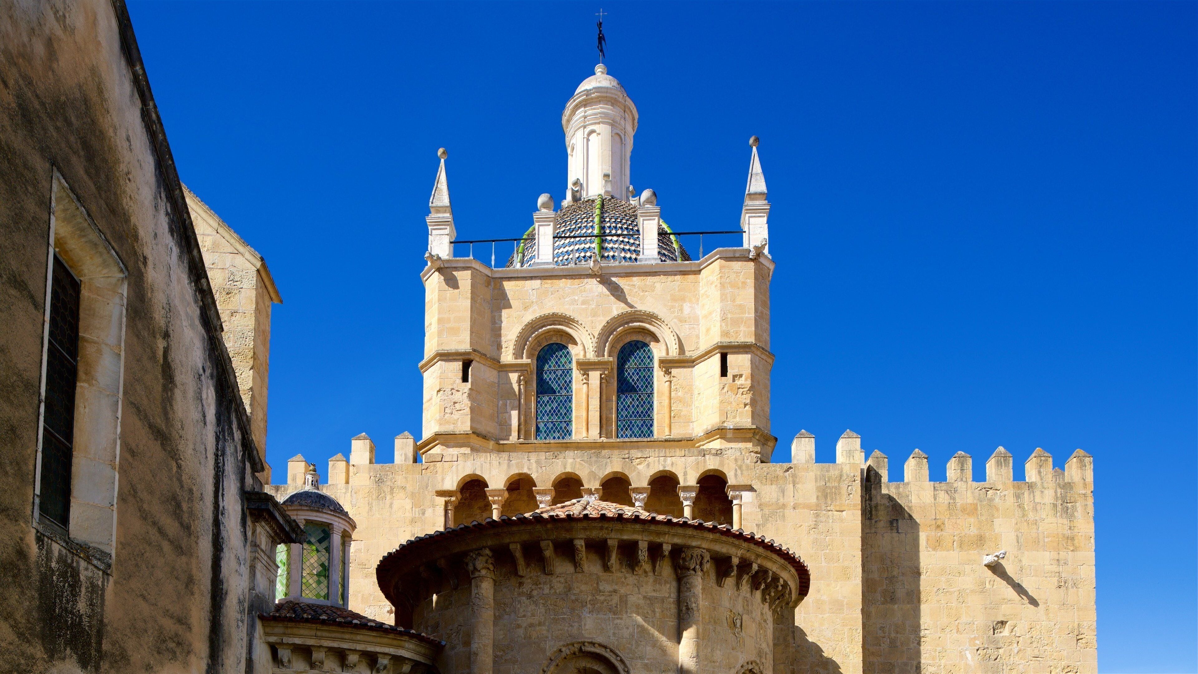 A historic building with a prominent tower, arched windows, and a tiled roof.