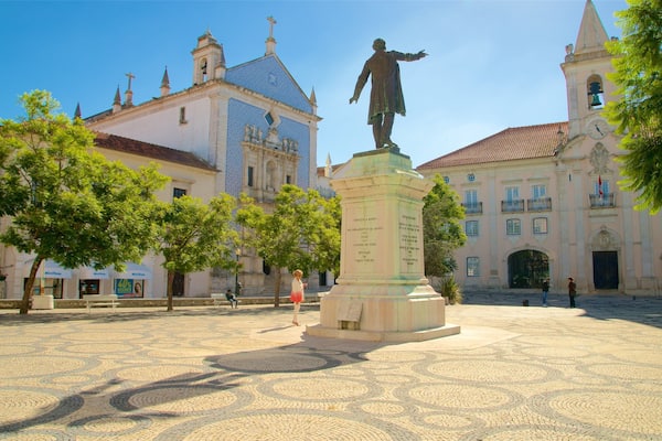 A plaza with a statue, historic buildings, and cobblestone pavement.