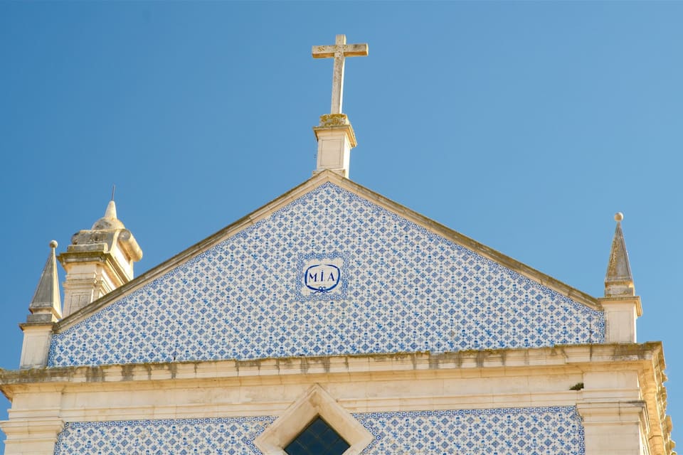 A church with a cross on top, blue and white patterned tiles, and a 'MIA' emblem.