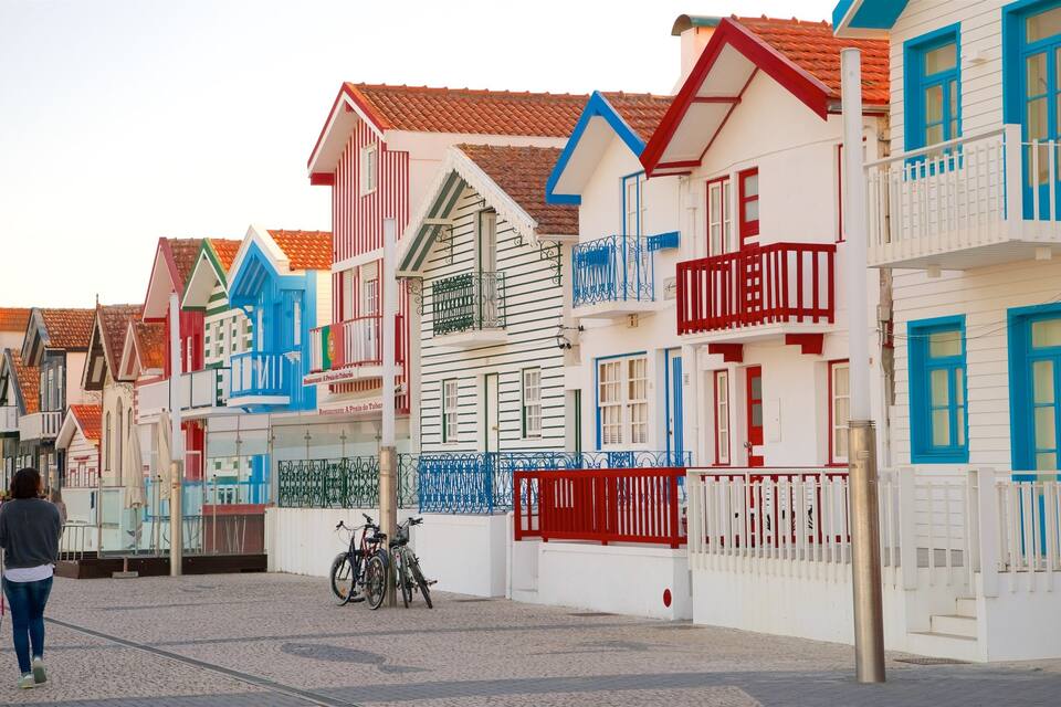 A street with colorful buildings, a bicycle, and two people walking.
