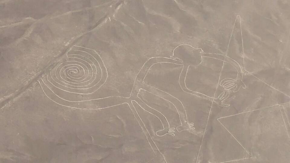 A desert landscape with ancient petroglyphs, including a spiral and a human figure.
