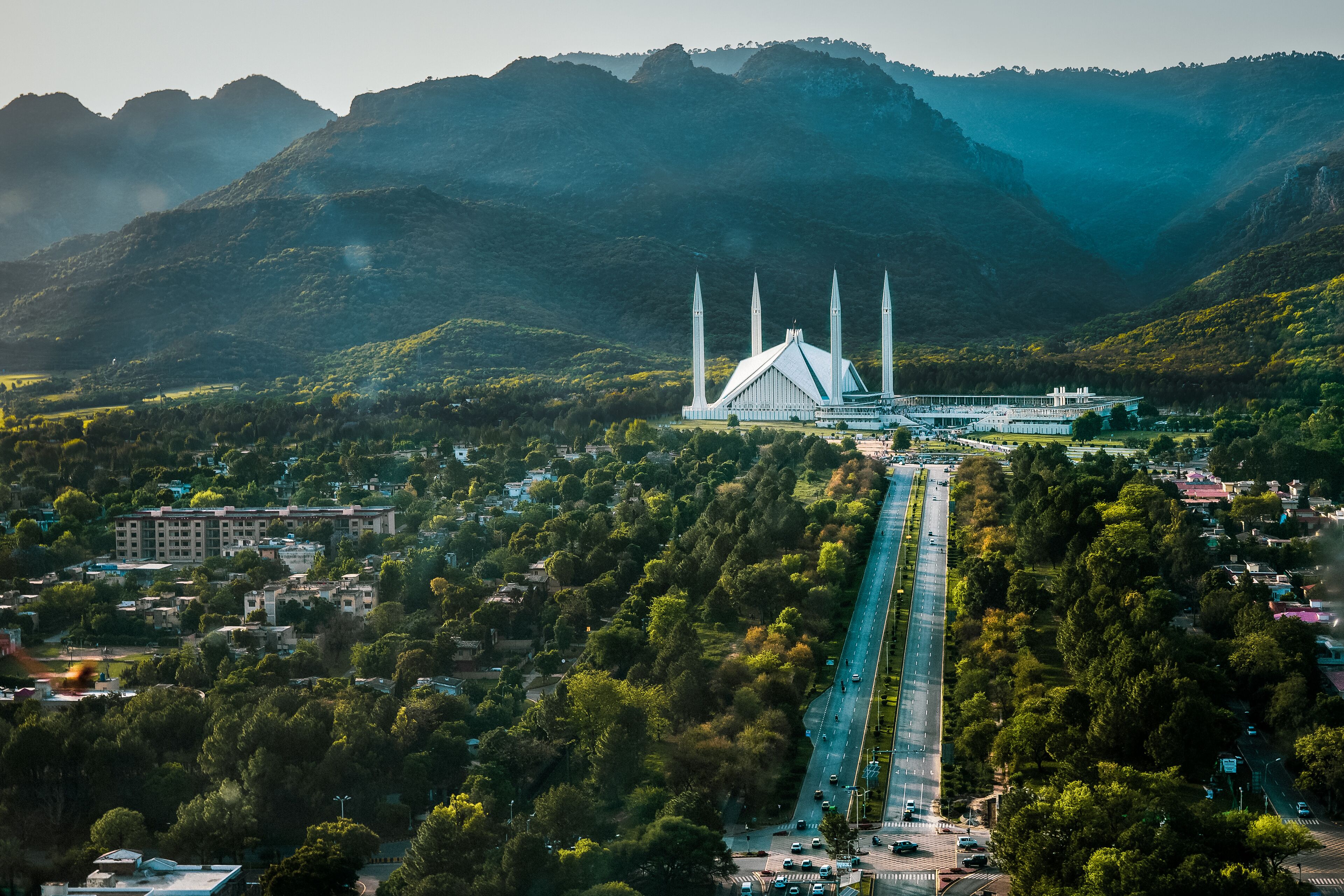 Islamabad / Pakistan - April 25 2019: Aerial photo of Islamabad, the capital city of Pakistan showing the landmark Shah Faisal Mosque and the lush green mountains of the city