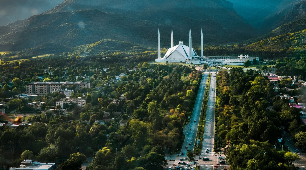 Islamabad / Pakistan - April 25 2019: Aerial photo of Islamabad, the capital city of Pakistan showing the landmark Shah Faisal Mosque and the lush green mountains of the city