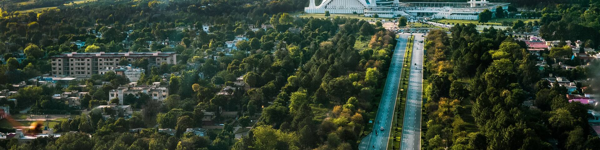 Islamabad / Pakistan - April 25 2019: Aerial photo of Islamabad, the capital city of Pakistan showing the landmark Shah Faisal Mosque and the lush green mountains of the city