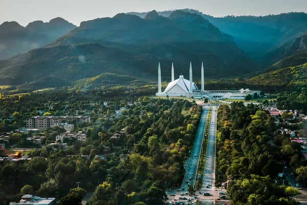 Islamabad / Pakistan - April 25 2019: Aerial photo of Islamabad, the capital city of Pakistan showing the landmark Shah Faisal Mosque and the lush green mountains of the city