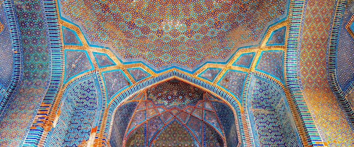 A detailed, ornate ceiling with geometric patterns and a central circular design.