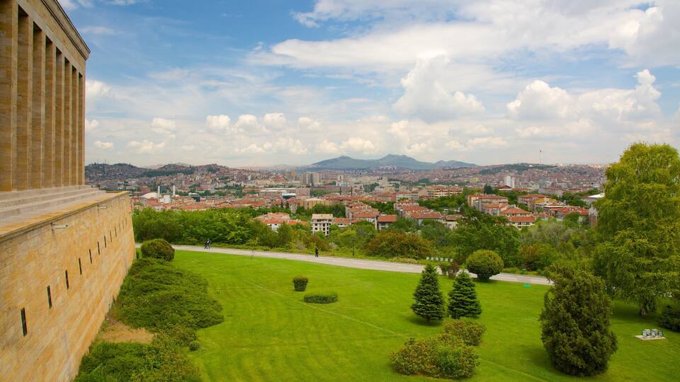 A cityscape with a prominent building on the left, a well-maintained park, and a distant mountain range.