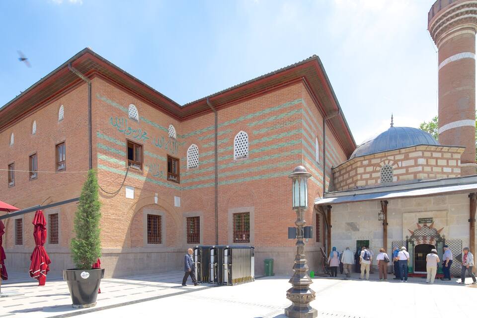 Edifici històric amb un minaret destacat i una cúpula, amb treballs de rajola intricats i finestres d'arc.