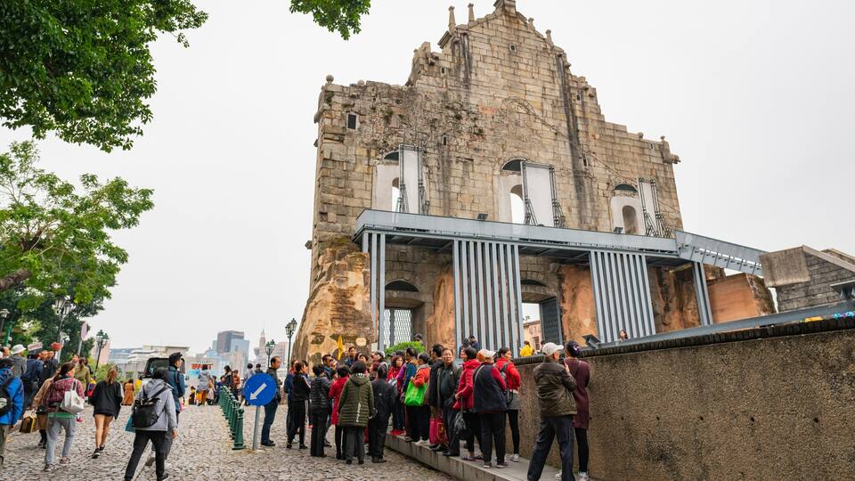 Un edificio histórico de piedra con una estructura metálica en primer plano.