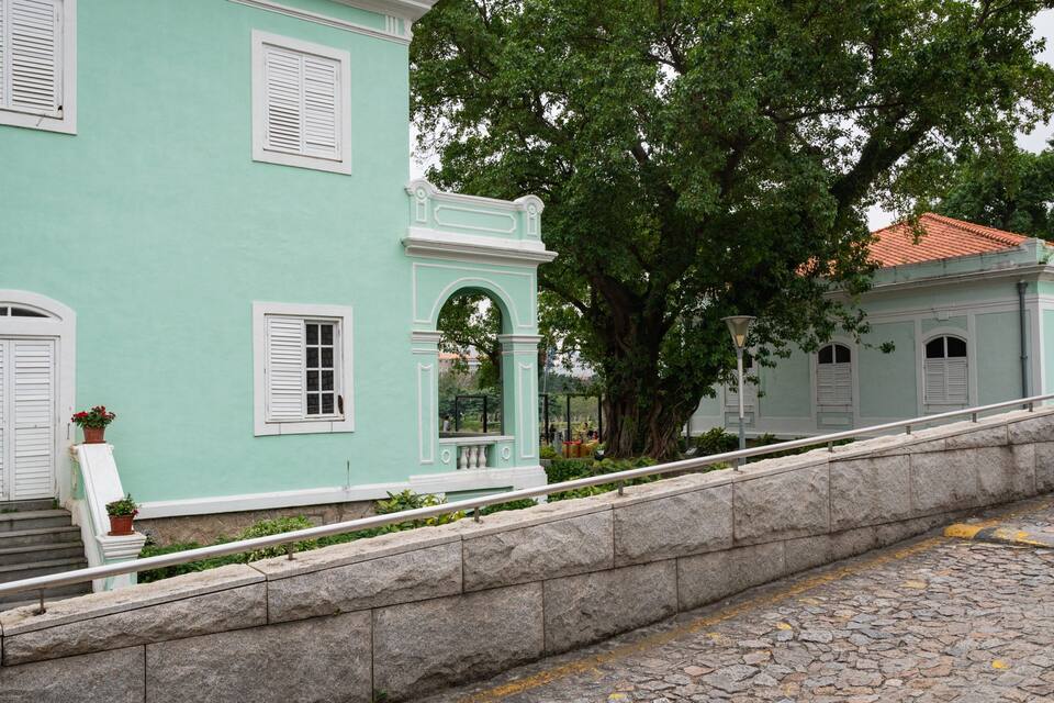 A historic building with white shutters and a stone staircase.