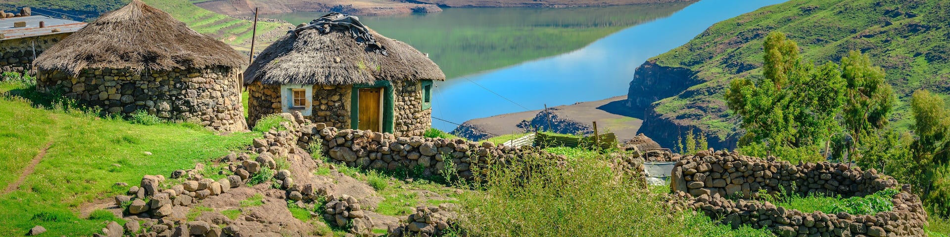 Lesotho traditional hut house homes in Lesotho village in Africa. Beautiful scenic landscape of village in daytime with typical huts built by villagers by the lake of Mohale Dam