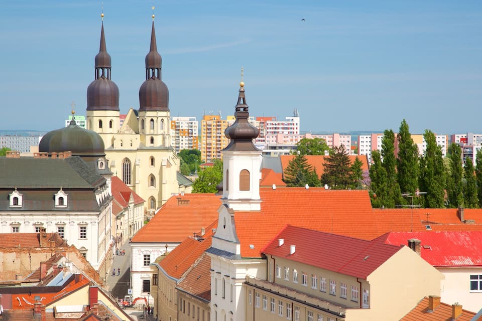 Paisagem urbana com edifícios históricos, incluindo uma igreja com duas cúpulas e um campanário.