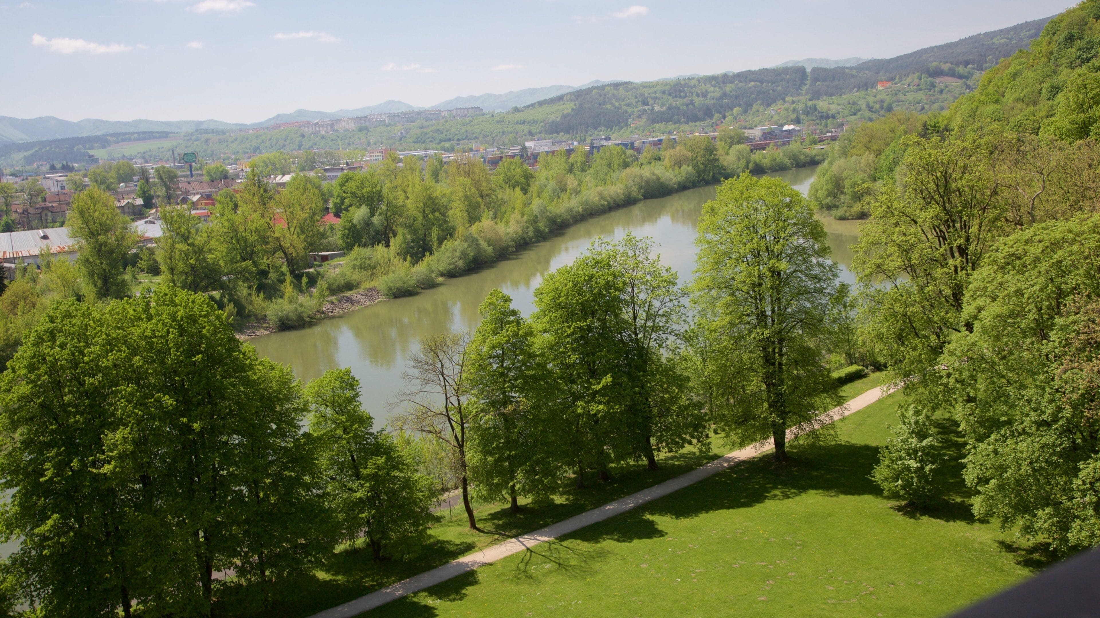 Castillo de Budatin ofreciendo una ciudad, un jardín y un río o arroyo