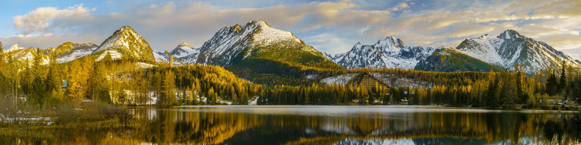 frosted bridge over the mountain lake Strbske Pleso in Slovakia, snowy mountains reflecting in the water