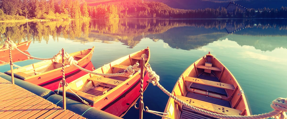 Majestic mountain lake in National Park High Tatra. Dramatic unusual scene. Sky glowing by sunlight. Strbske pleso, Slovakia, Europe. Beauty world. Retro style filter. Instagram toning effect.