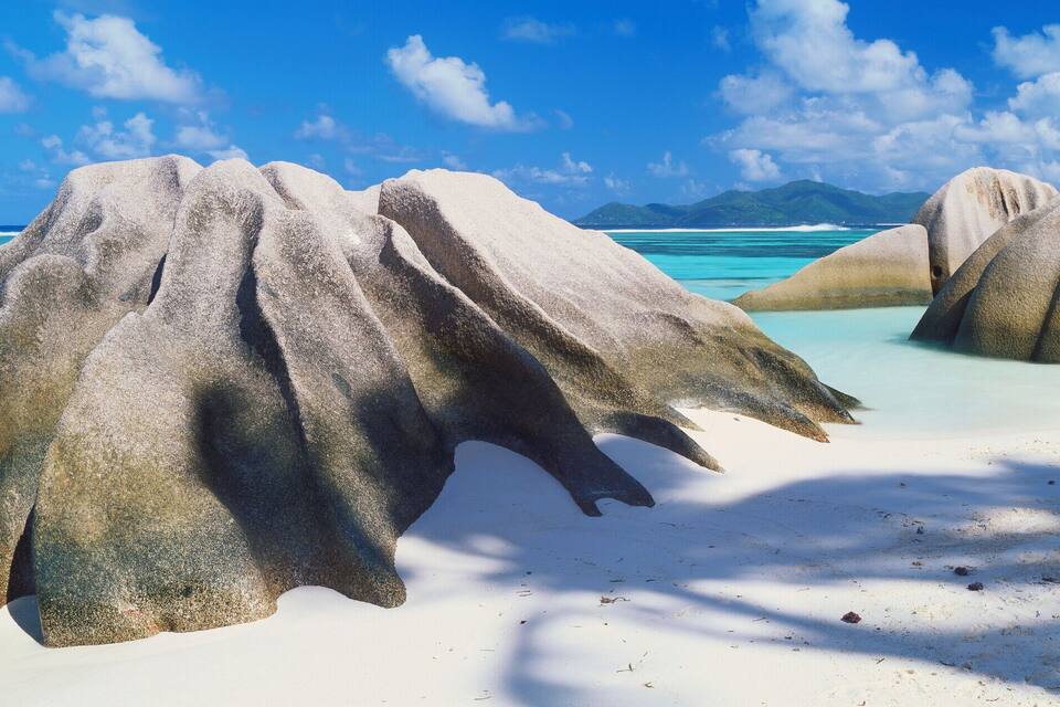 Una playa con grandes rocas y agua turquesa cristalina.