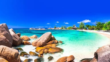 Panoramic view of Anse Lazio beach with granite rocks and turquoise ocean, Praslin Island, Seychelles. Most beautiful tropical paradise coastline at sunny day.