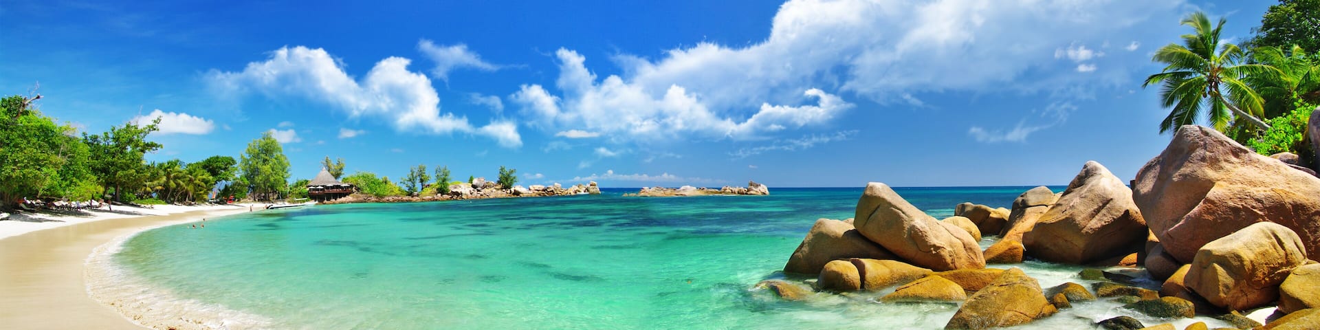 Panoramic view of Anse Georgette beach at Constance Lemuria Resort, Praslin, Seychelles. Tropical bay with granite rocks and turquoise ocean water.