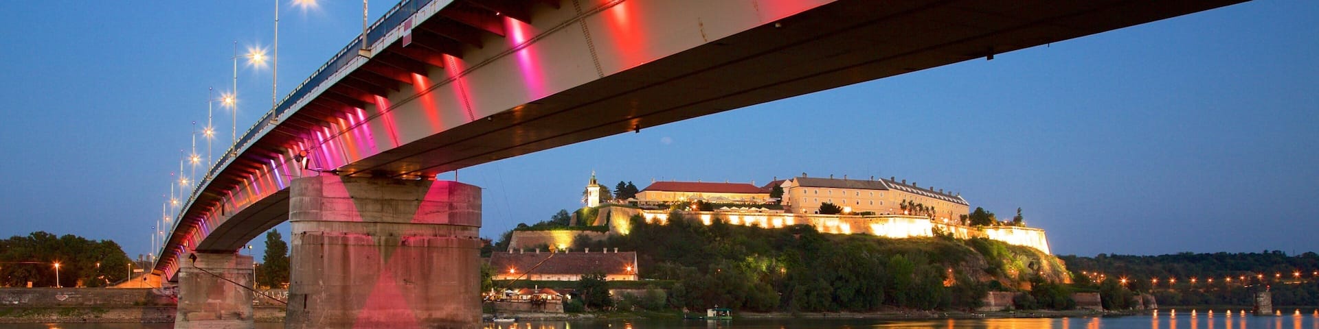 Petrovaradin Fortress showing a river or creek, night scenes and a bridge