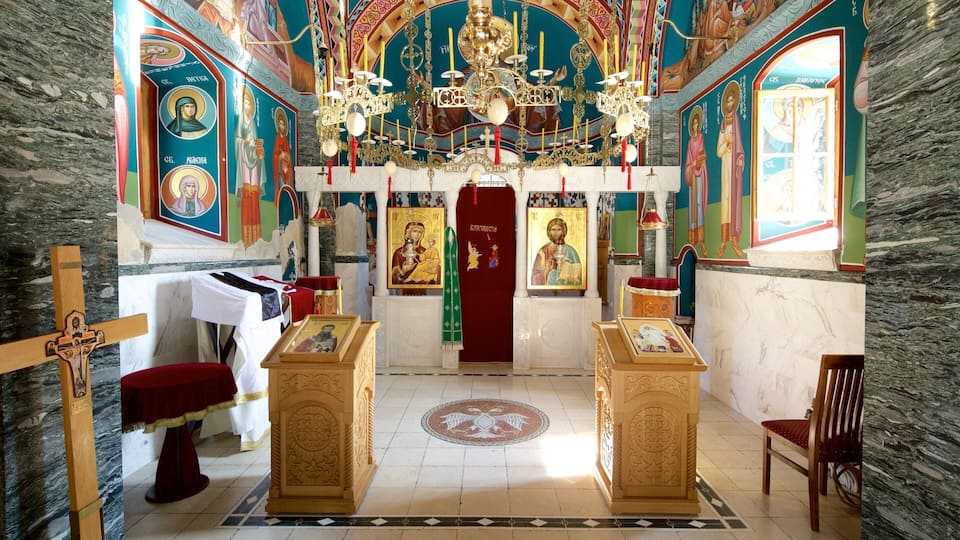 An ornate church interior with religious icons, a chandelier, and marble walls.