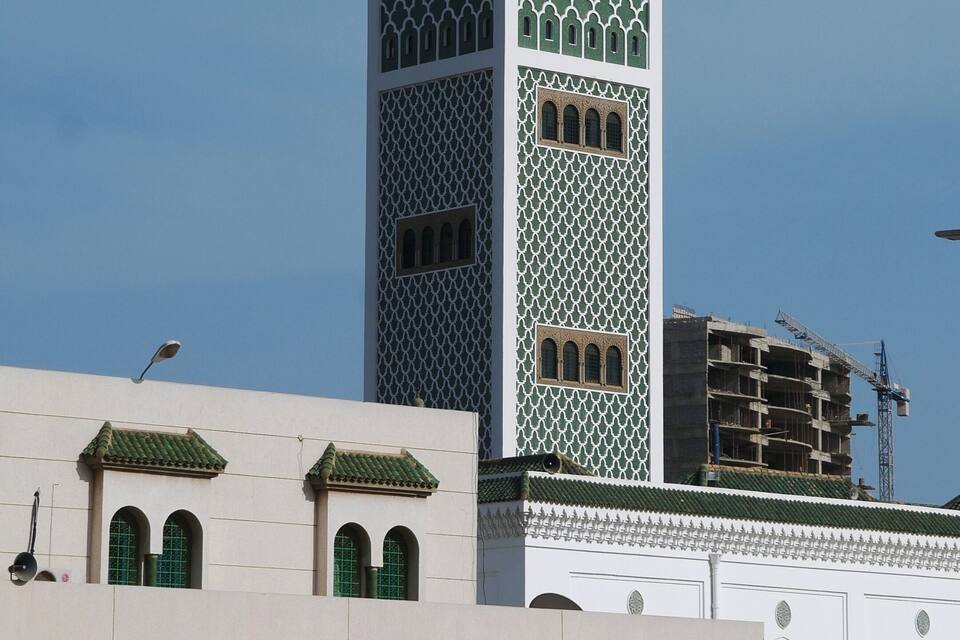 Una moschea con un minareto alto e finestre ad arco.