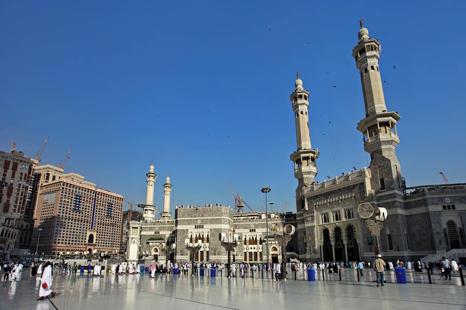 A large mosque with two tall minarets and a spacious courtyard.