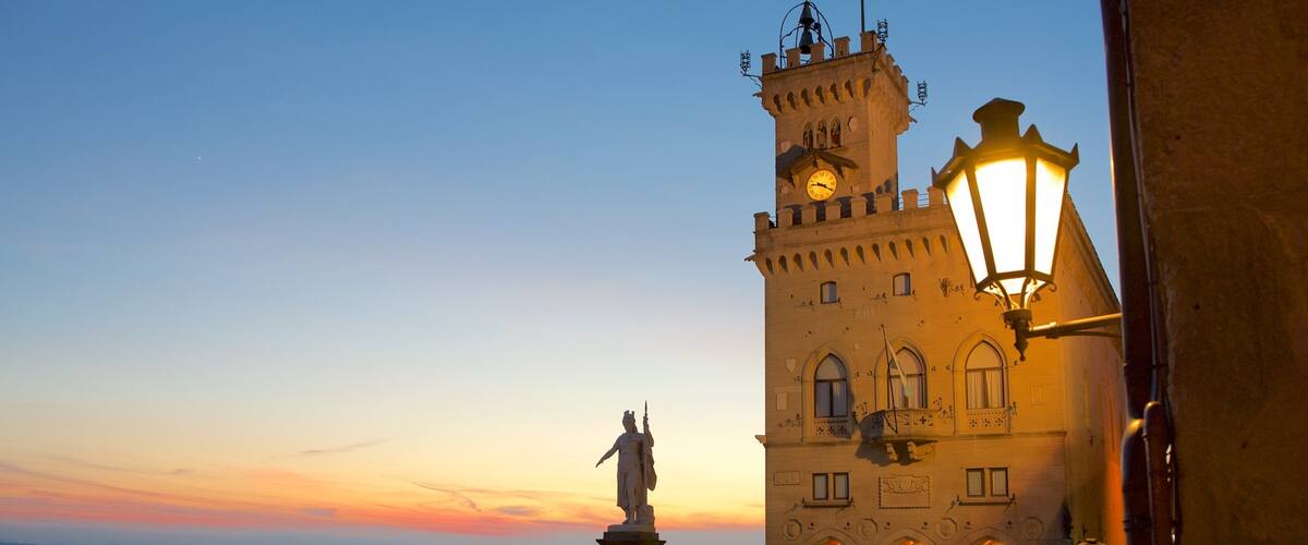 Palazzo Pubblico mostrando un monumento, un parque o plaza y una puesta de sol