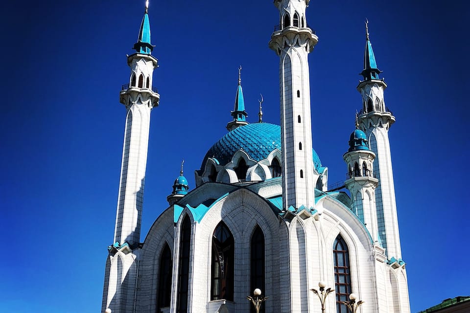 Une grande cathédrale blanche, dotée de coupoles bleues et de nombreuses tours.