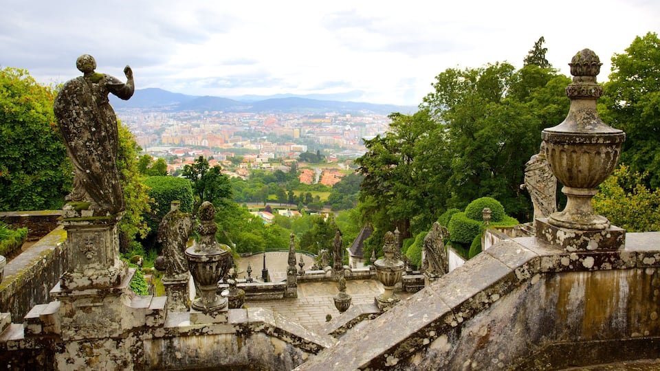 A historic garden with statues and ornate urns, overlooking a cityscape.