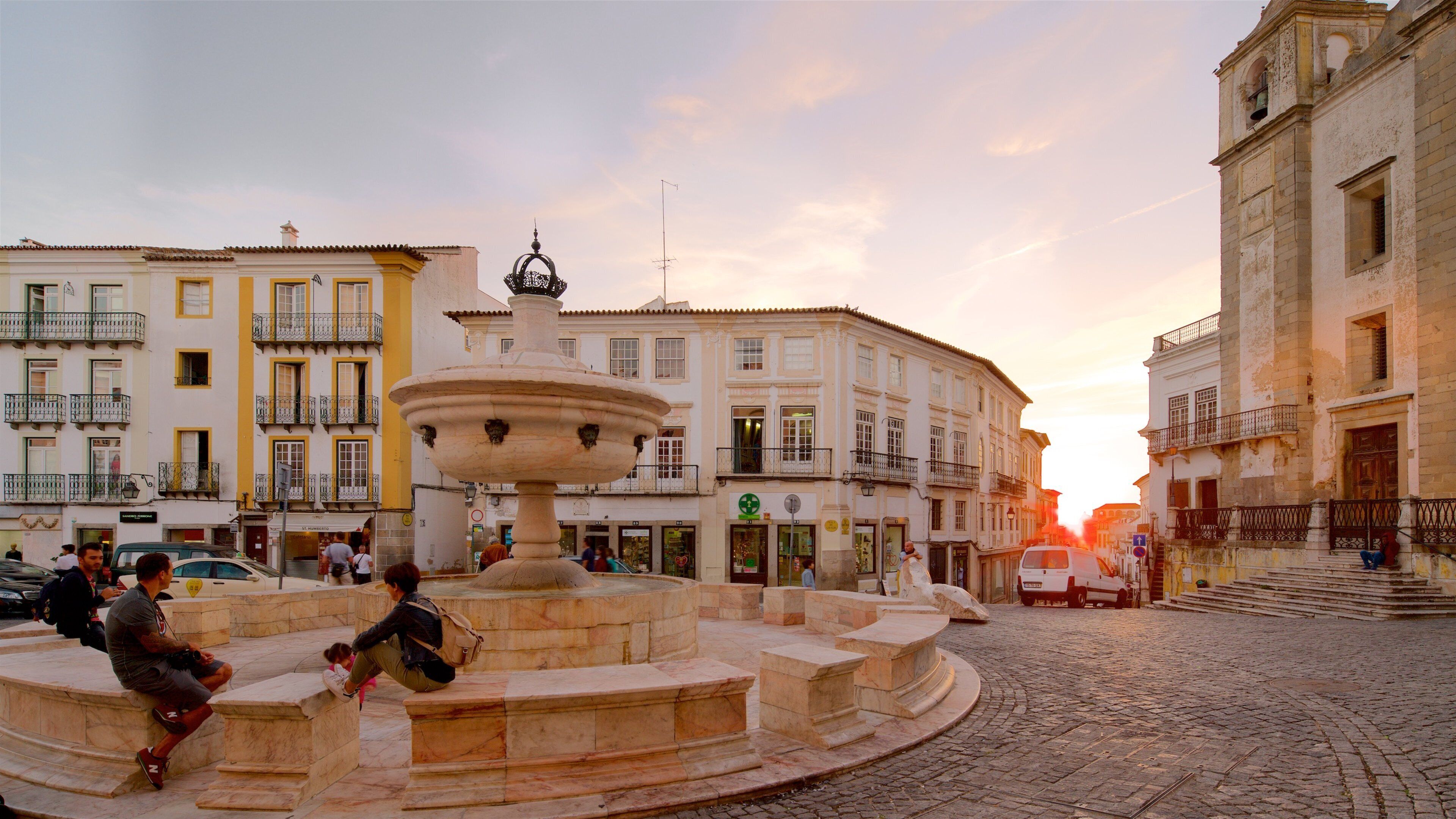 吉拉朵廣場 设有 夕陽 和 噴泉 以及 一小群人