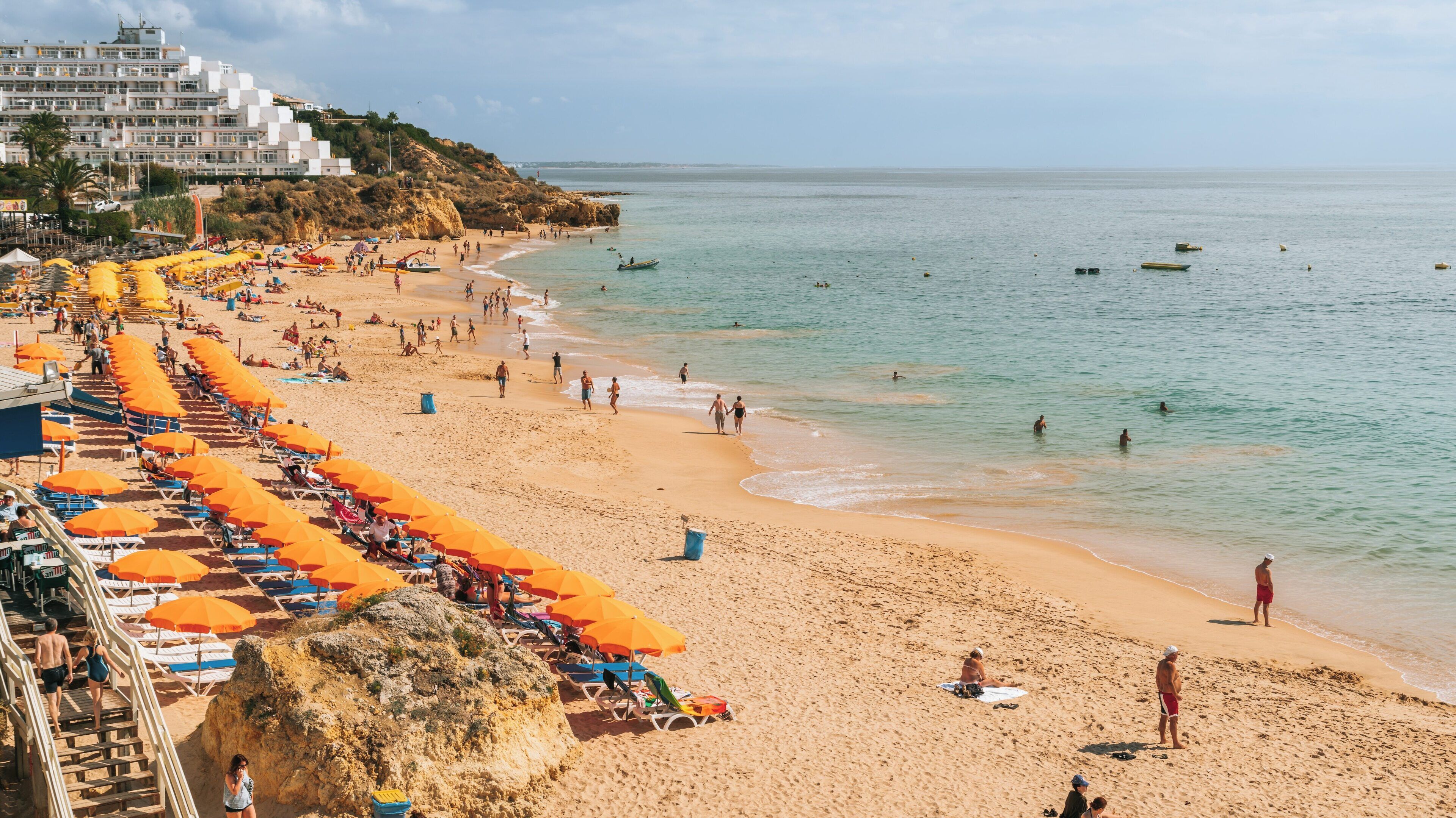 Enjoying a sunny day at Oura Beach in Santa Eulália, Albufeira, Faro District of Portugal with vibrant umbrellas and clear waters
