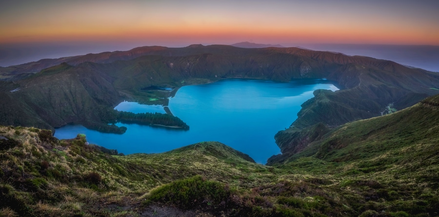 Paisagem montanhosa com um lago grande rodeado por penhascos íngremes.