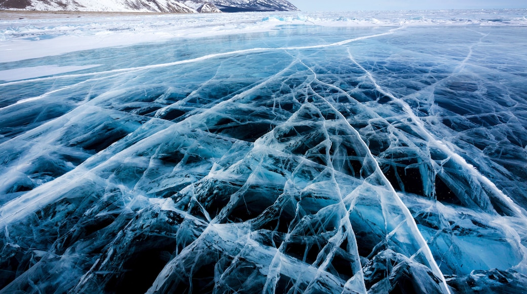 View of beautiful drawings on ice from cracks and bubbles of deep gas on surface of Baikal lake in winter, Russia