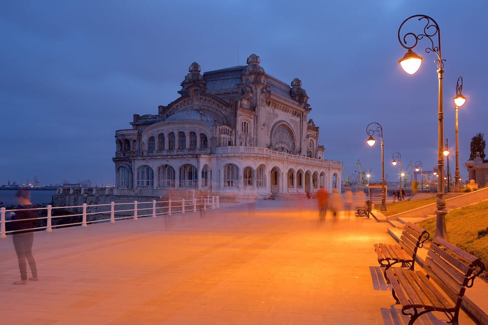 A historic building with ornate architecture by the waterfront at dusk.