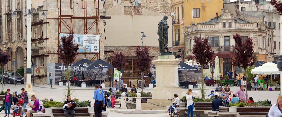 A bustling square with a statue, outdoor seating, and historic buildings.