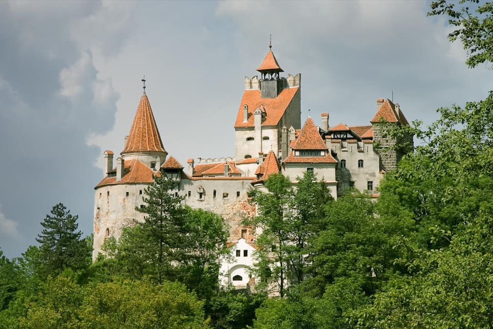 Un château doté de nombreuses tours, dont une tour centrale particulièrement imposante.