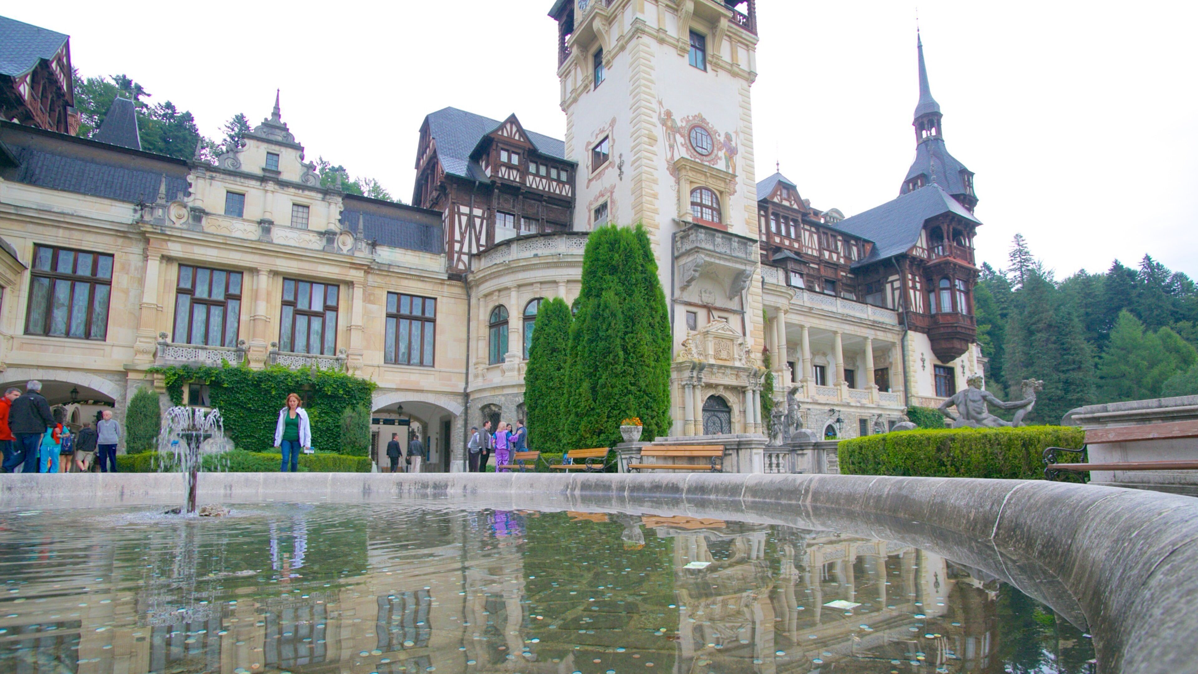 Peles Castle featuring chateau or palace, a fountain and heritage architecture