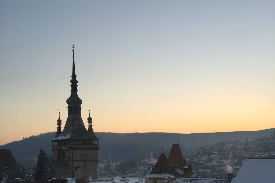 En kirke med et højt spired og snedækkede tage i en by.