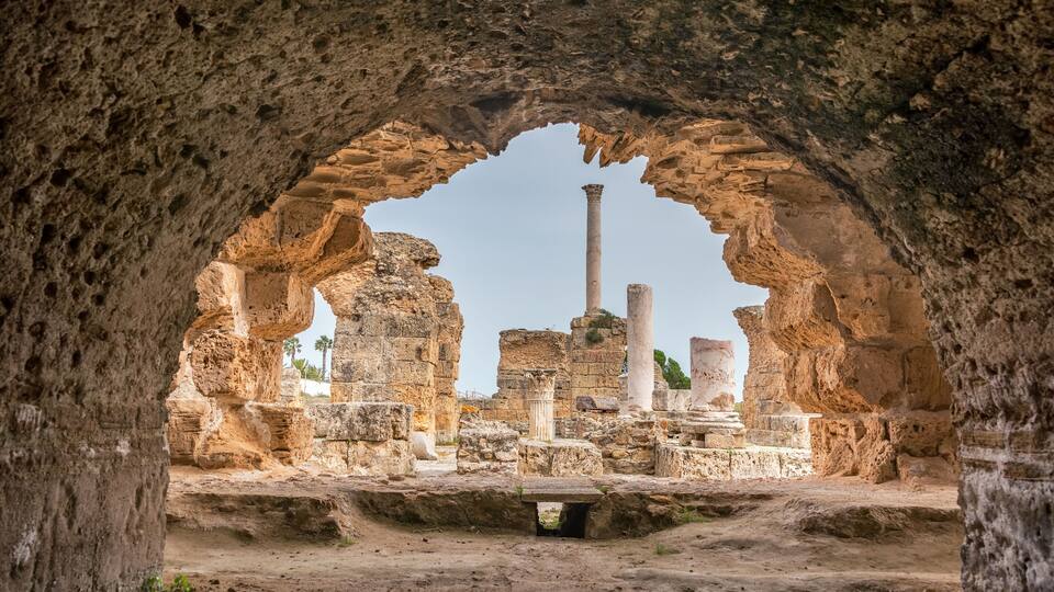 Ancient ruins with stone columns and arches.