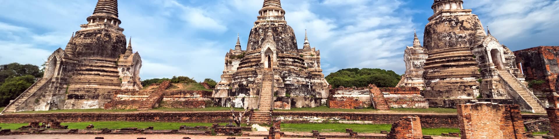 Ruines d’un temple antique, avec des structures à plusieurs niveaux, sous un ciel d’un bleu éclatant.