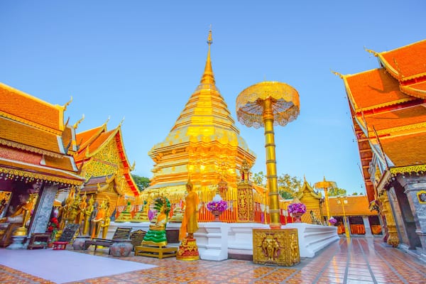 Un stupa doré, entouré d’édifices de style architectural traditionnel thaïlandais.
