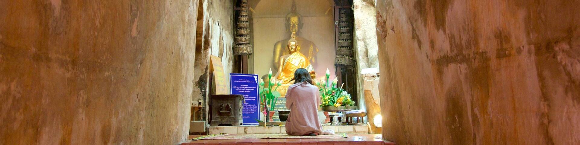 A large golden statue in a temple corridor.