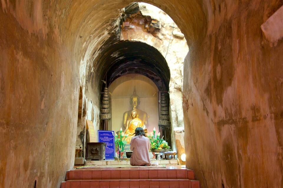 A large golden statue in a temple corridor.