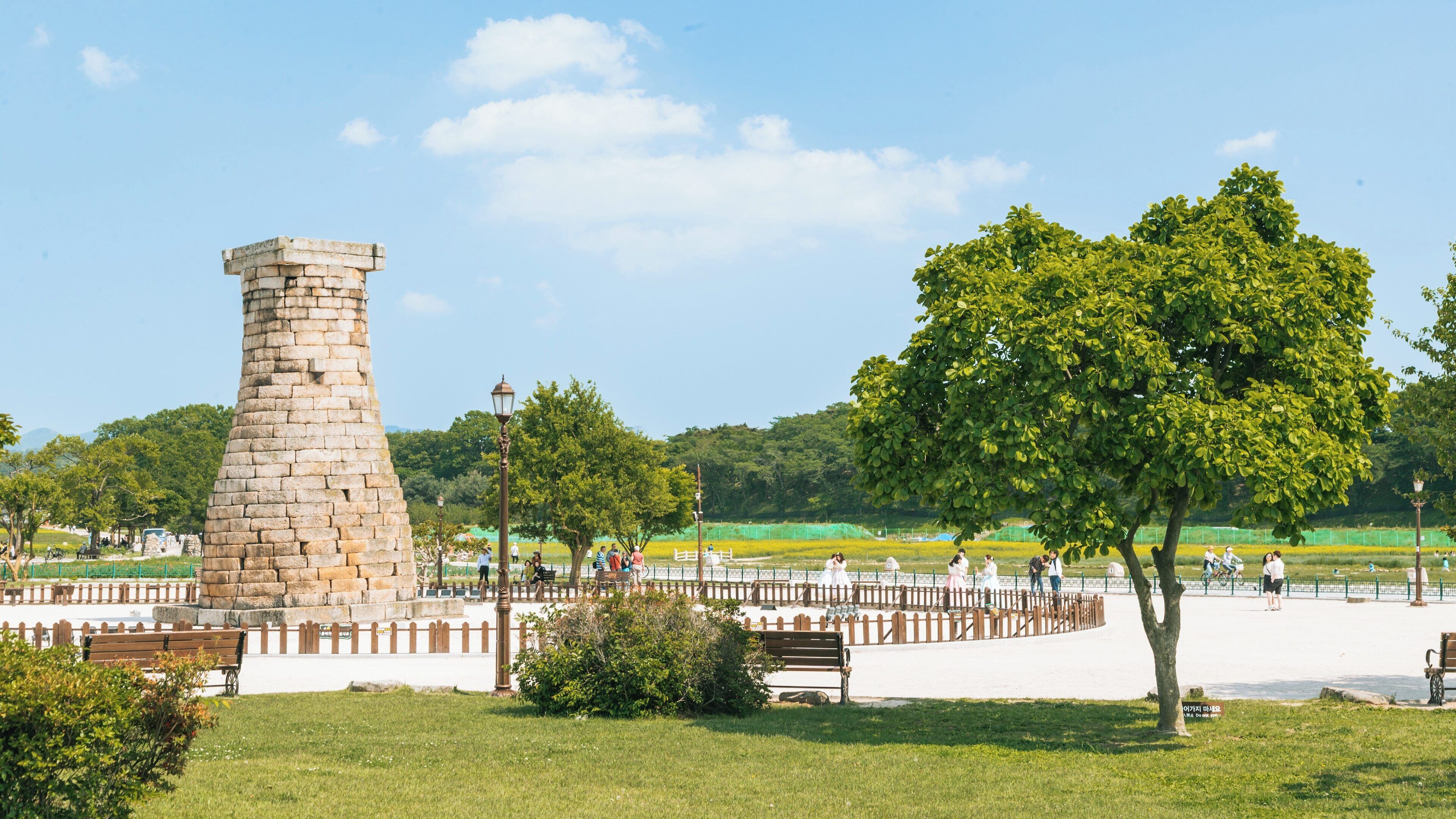 Exploring Cheomseongdae in Gyeongju, North Gyeongsang, South Korea on a clear sunny day with visitors enjoying the park