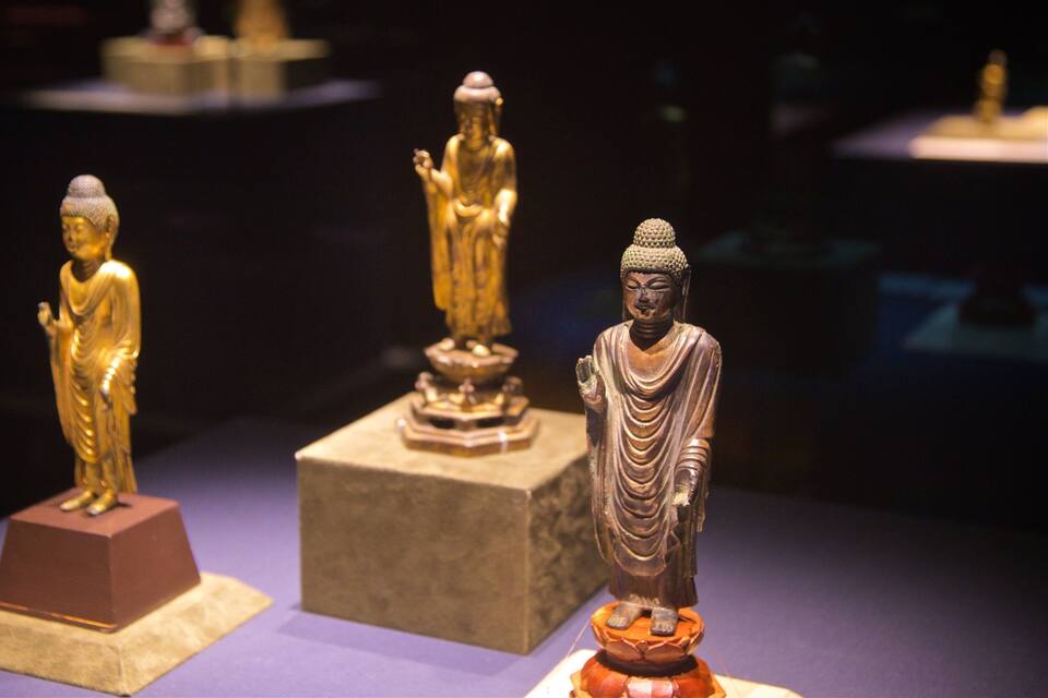 Tres estatuas de Buda sobre pedestales.