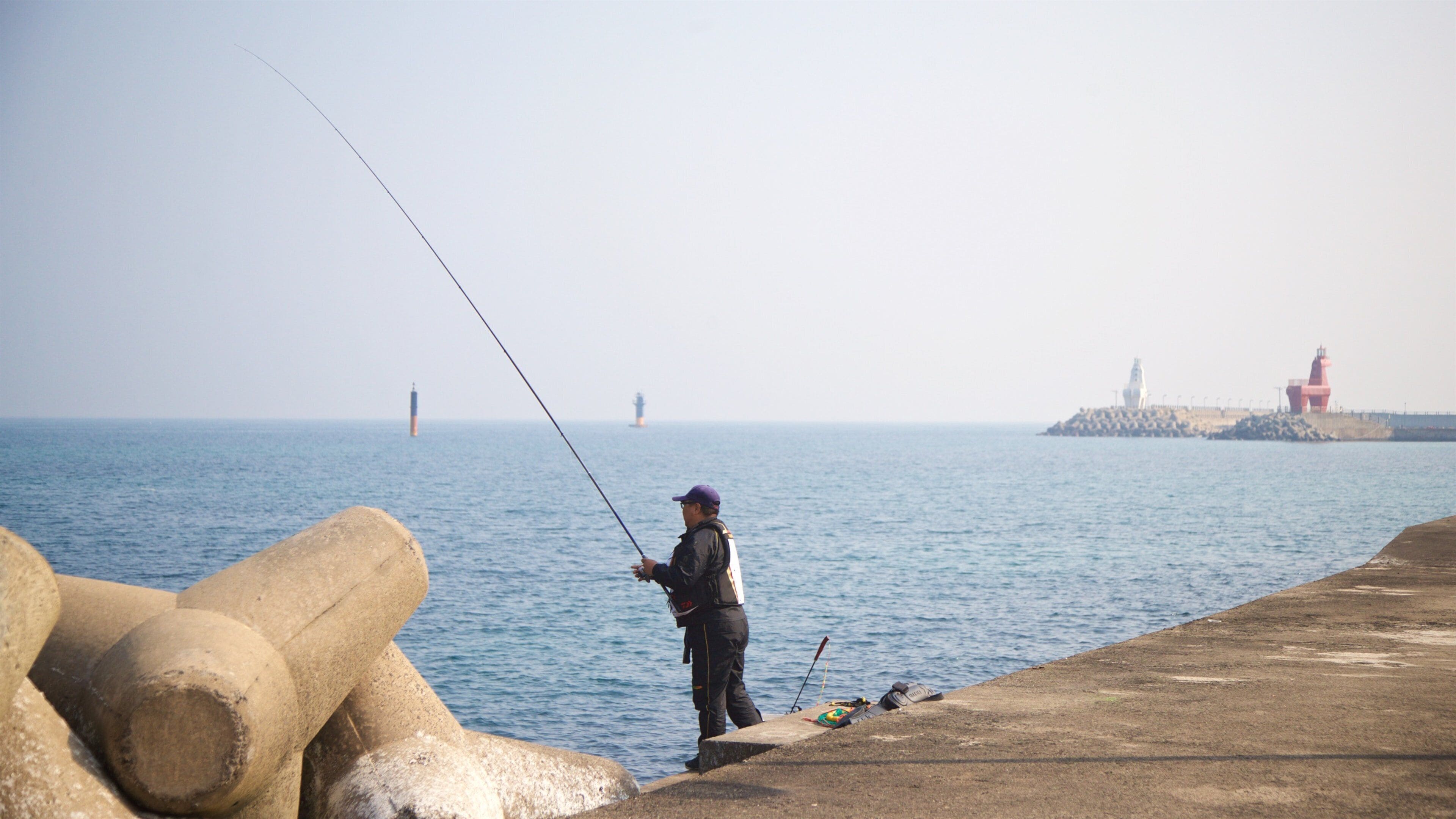 Iho Beach featuring general coastal views and fishing as well as an individual male