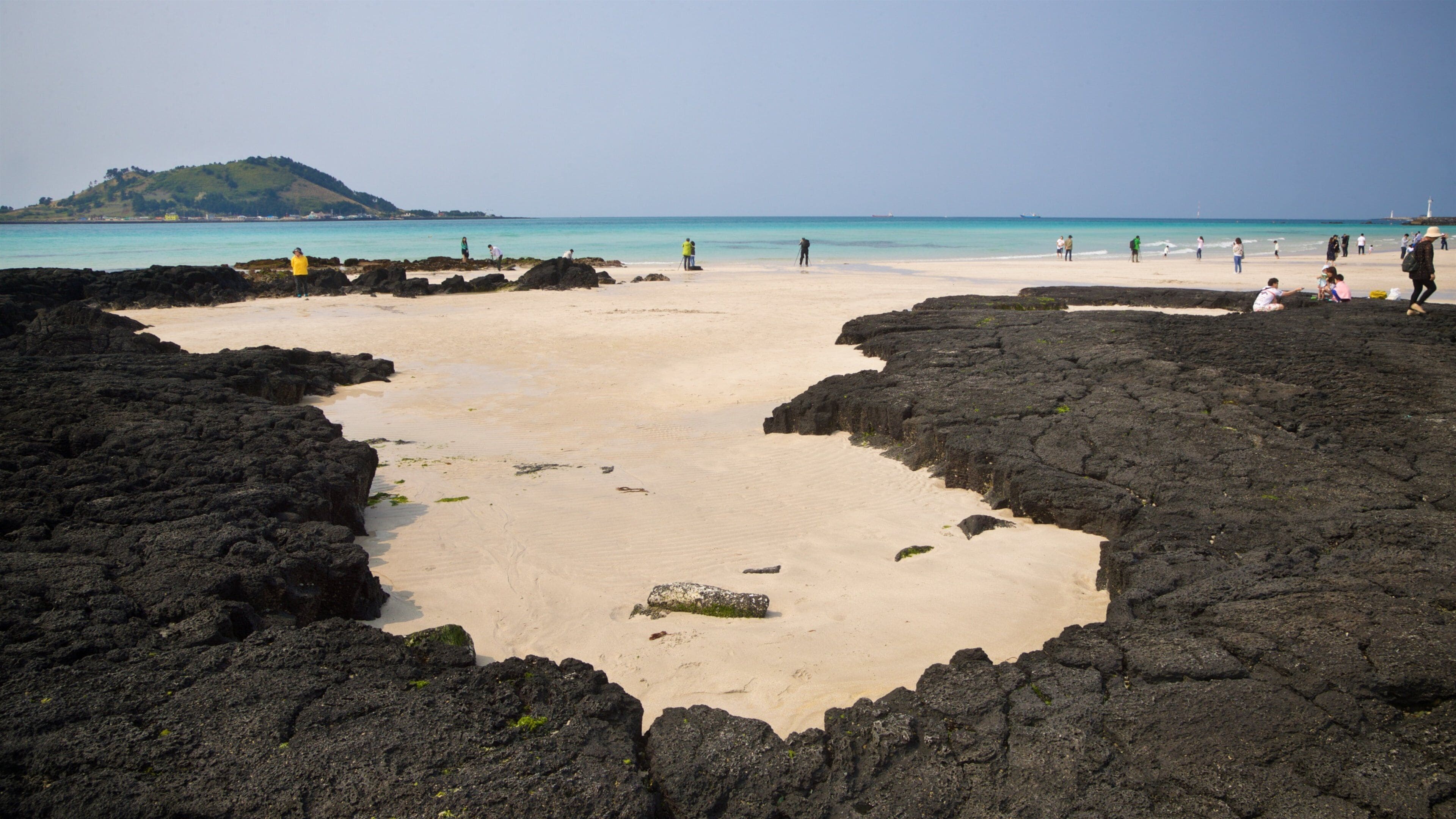 Hyeopjae Beach showing a sandy beach, rocky coastline and general coastal views