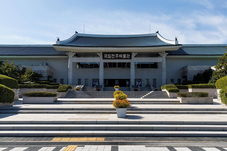 A traditional Korean building with a curved roof and steps leading up to the entrance.